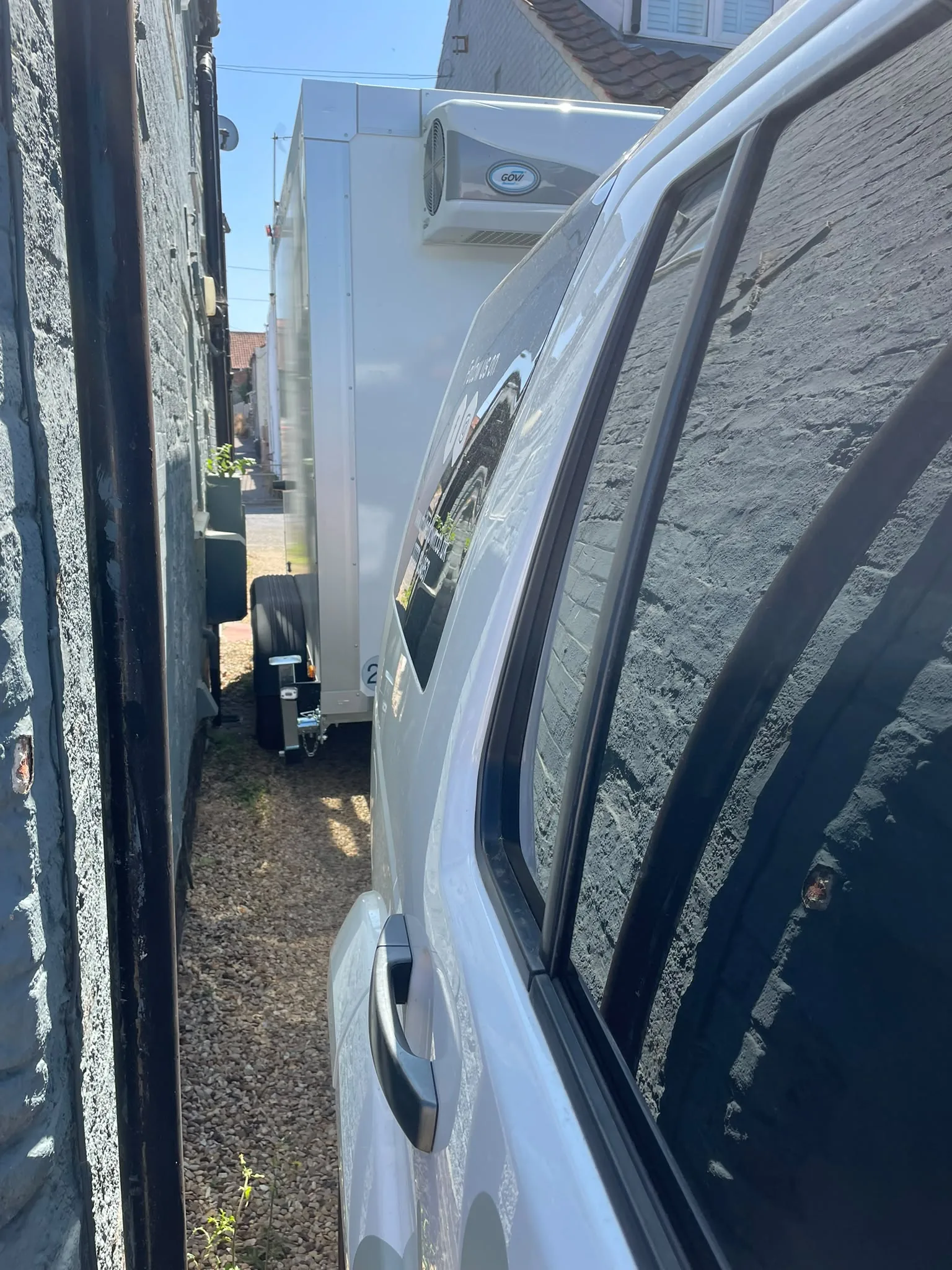 Side view of narrow refrigerated trailer in tight access location, Wells