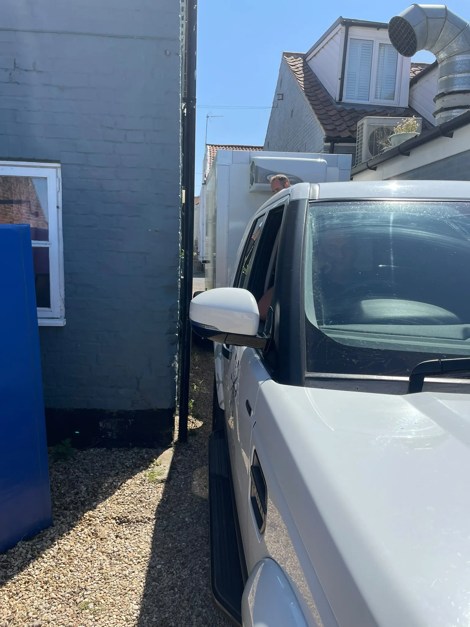 Narrow refrigerated trailer positioned between buildings in Wells, Norfolk